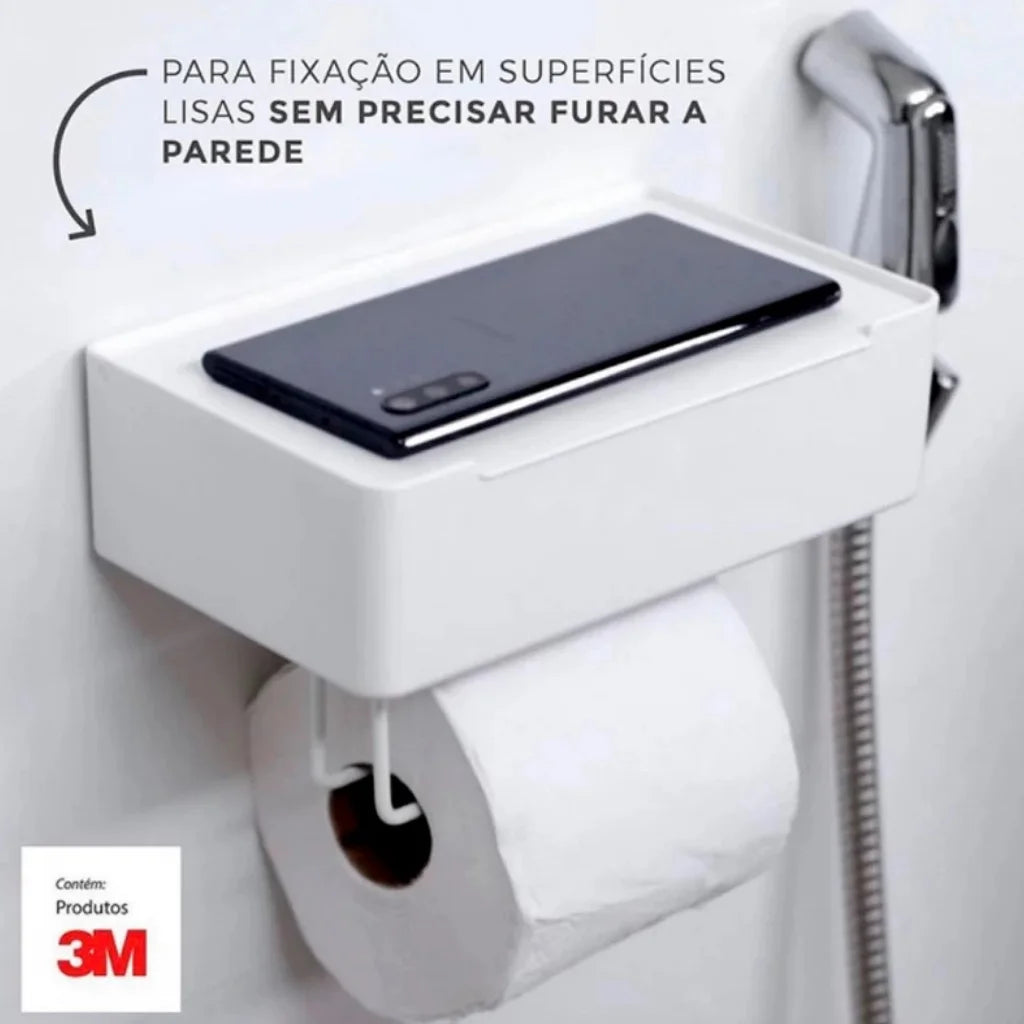Vista do produto instalado na parede do banheiro, mostrando a organização do papel higiênico e lenços, e a praticidade do suporte para smartphone.